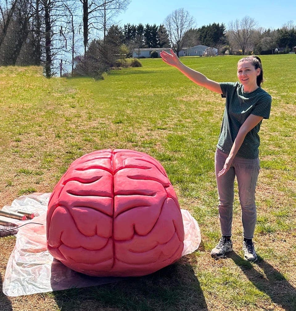 A hand-built oversized brain prop in a field