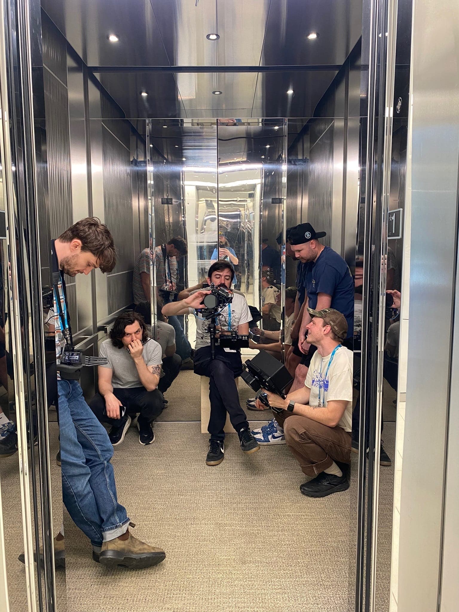 Crew squeezed into a mirrored elevator for a shot