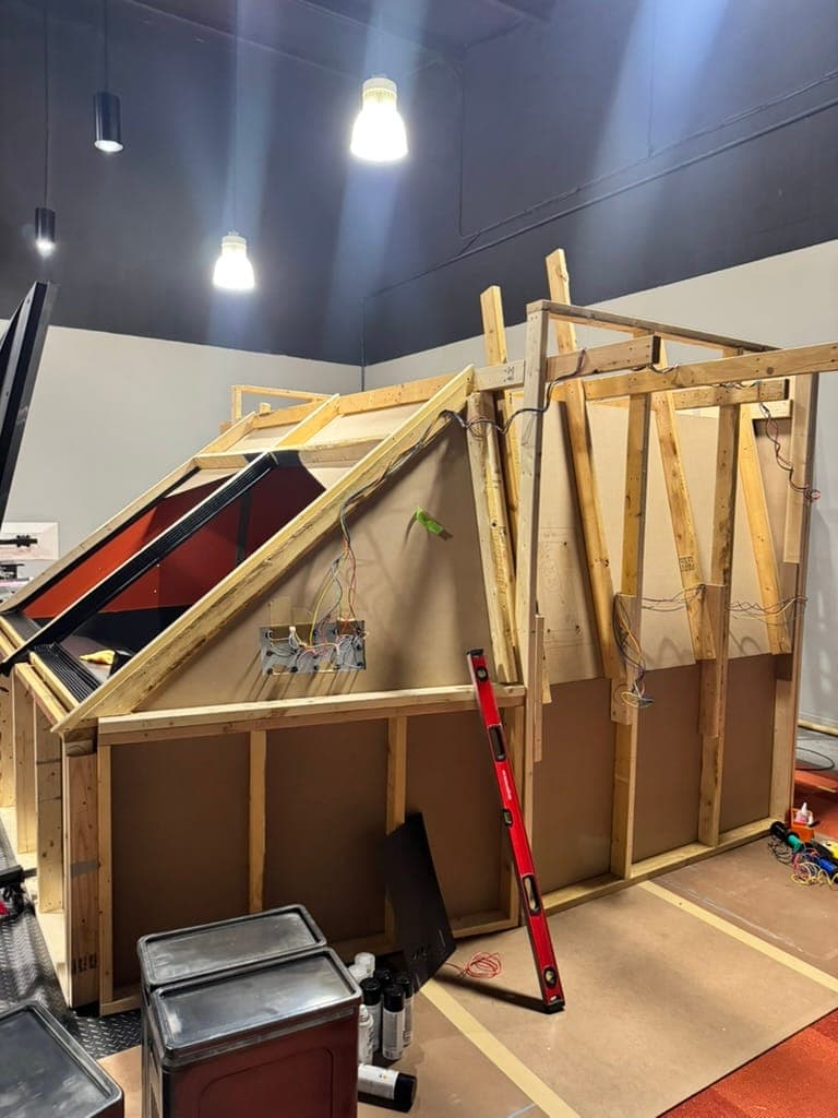 The spaceship hull framed in lumber on stage, wiring already run through the walls